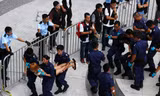  Cảnh sát Hồng Kông khiêng từng sinh viên ra khỏi trụ sở chính quyền - Ảnh: Reuters 