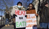 Những người Anh cầm biểu ngữ (Sưởi ấm hay ăn/Tất cả chúng tôi cần sự ấm áp) trong một cuộc biểu tình kêu gọi chính phủ giúp đỡ người dân chi trả hóa đơn năng lượng của họ. Ảnh: AP.