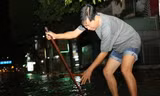 Người dân khu phố 1, phường Long Bình Tân khơi cống rảnh để nước thoát nhanh hơn trên quốc lộ 51. Ảnh: Phước Tuấn