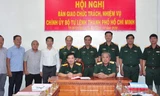 Thiếu tướng Nguyễn Minh Hoàng (thứ 4 từ bên phải sang) và các đại biểu chứng kiến Thiếu tướng Ngô Tuấn Nghĩa và Đại tá Phan Văn Xựng ký biên bản bàn giao. Ảnh: hcmcpv