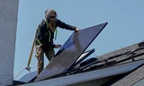 Một nhân viên đang lắp đặt tấm pin trên mái nhà ở Lakewood, Ohio, ngày 16/4. (Ảnh: AP)
