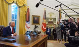Ông Trump trao đổi với các phóng viên khi ông ký sắc lệnh tại Phòng Bầu dục ngày 30/1. (Ảnh: AP)