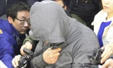Thuyền trưởng Lee Joong Seok che mặt trước vòng vây của báo giới. 