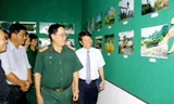 NSNA Vũ Quốc Khánh- Chủ tịch Hội NSNA Việt Nam cùng Trung tướng Đinh Văn Cai, Chính ủy Quân khu 9 và đại biểu tham quan triển lãm. Ảnh: Dương Thu