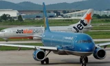 Máy bay Vietnam Airlines (màu xanh) và Jetstar Pacific trên sân bay - Ảnh minh họa