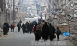 Người dân Syria rời khỏi khu vực Sukkari để đến khu vực an toàn hơn do quân nổi dậy chiếm giữ ở đông nam thành phố Aleppo ngày 12/12. Ảnh: AFP/TTXVN.