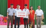 Ông Trần Thanh Lâm, Phó Tổng Biên tập Báo Tiền Phong, Phó giám đốc Quỹ hỗ trợ tài năng trẻ Việt Nam cùng đại diện lãnh đạo địa phương, nhà trường trao tặng học bổng cho em Lê Đức Hậu. Ảnh: Hoàng Lam