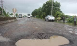 Nhiều đoạn bong tróc chưa kịp “vá”, mặt đường đã xuất hiện thêm các ổ voi, ổ gà khiến người dân bất an. Ảnh: Tr. Định