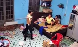 N. dùng cây lau nhà đánh mẹ. Ảnh cắt từ clip.