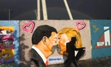 Một người đi qua bức tranh tường ở Berlin vẽ Tổng thống Mỹ Donald Trump và Chủ tịch Trung Quốc Tập Cận Bìnhảnh: AP