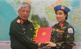 Thượng tướng Nguyễn Chí Vịnh trao quyết định của Chủ tịch nước cho thiếu tá Đỗ Thị Hằng Nga. Ảnh: Nguyễn Minh