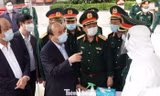 Thủ tướng Nguyễn Xuân Phúc trò chuyện với nhân viên xe xét nghiệm cơ động của Viện Y học dự phòng Quân đội, tại Cục Quân y, chiều 22/3. Ảnh: Nguyễn Minh