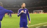 Fabregas hướng lên khán đài Emirates và chỉ tay vào logo Chelsea