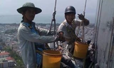 Những người thợ lau kính phải cheo leo giữa không trung để mưu sinh - Ảnh: Bảo Nguyên 