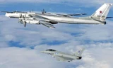Một chiếc Tu-95 Bear (phía trên) được chiến đấu cơ Typhoon hộ tống ra khỏi không phận Anh tháng 4-2014. Ảnh: UK Mod