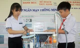 Khánh và Dung lắp đặt thử nghiệm hệ thống đập ngăn mặn thông minh sử dụng năng lượng mặt trời.