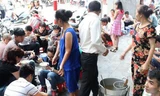 Ăn phở kiểu bưng tại quán trên vỉa hè Hàng Trống. Ảnh: Người lao động. 