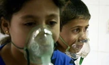 Trẻ em Syria thở bằng mặt nạ trong một vụ việc các nhà hoạt động gọi là vụ tấn công bằng khí đọc ở ngoại ô Damascus hồi tháng 8/2013. Ảnh: Reuters