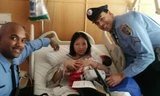 Hai cảnh sát Caban và James chụp ảnh với sản phụ sau khi giúp cô sinh con trên tàu điện ngầm. Ảnh: USA Today