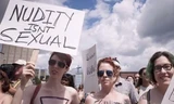Nhiều phụ nữ để ngực trần tham gia cuộc biểu tình. Họ cầm biểu ngữ viết "Khỏa thân không phải là nhục dục". Ảnh: RT