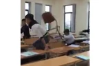 Nhóm sinh viên cao đẳng du lịch vác vả ghế đánh nhau trong phòng học. Ảnh cắt từ clip.