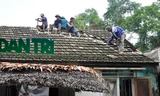 Người dân xã Sơn Trường đang giúp bà Ái sửa lại mái nhà bị sét đánh hỏng.