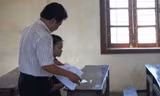 Giám thị đánh số báo danh cho thí sinh duy nhất thi môn Sử tại hội đồng thi trường THPT Thái Lão.