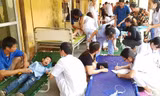 Bệnh viện phải kê thêm giường ở hành lang và sân để khám, chữa cho học sinh. Ảnh: NT