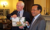 Ông Phạm Quang Nghị trao tặng Thượng nghị sĩ John McCain bức ảnh chụp bia chứng tích bên hồ Trúc Bạch (Ảnh: HNM)