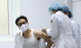 Phó Thủ tướng Vũ Đức Đam động viên người tiêm thử nghiệm vắc xin Nano Covax Ảnh: Thái Hà