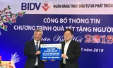 Tổng Biên tập báo Tiền Phong Lê Xuân Sơn (phải) nhận những phần quà từ BIDV để trao cho người nghèo dịp Tết. Ảnh PV