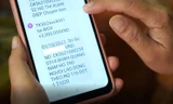 Người lao động kiểm tra tin nhắn báo nhận tiền hỗ trợ từ Quỹ Bảo hiểm thất nghiệp.