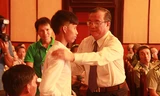 Ông Huỳnh Văn Tí, Thứ trưởng Bộ LĐ-TB&XH, trao quà, động viên gia đình em Nguyễn Đức Ánh, một trong những nạn nhân bom mìn sót lại sau chiến tranh.