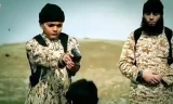 Chiến binh IS nhí xuất hiện trong video tuyên truyền của tổ chức giơ súng chuẩn bị bắn một con tin. Ảnh: IBTimes.