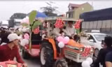 Chiếc máy cày được trang trí thành xe hoa “đại náo” quốc lộ 1 A. (Ảnh cắt từ clip).