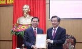 Ông Nguyễn Quang Dương, Ủy viên Ban chấp hành Trung ương Đảng, Phó Trưởng Ban Tổ chức Trung ương (phải) trao quyết định cho đồng chí Nguyễn Long Hải. Ảnh: TTXVN