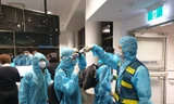 Đo thân nhiệt hành khách trước khi lên máy bay tại Úc, toàn bộ hành khách và tổ bay đều mặc trang phục bảo hộ y tế.