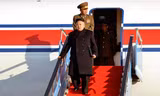 Ông Kim Jong-un đang bước xuống từ một máy bay.