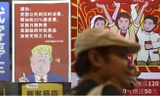 Một poster ở Quảng Châu có hình ông Trump kèm theo câu nói rằng tất cả khách hàng Mỹ sẽ bị đánh thuế 25% sau khi Mỹ tăng thuế lên hàng Trung Quốc. (Ảnh: AP)