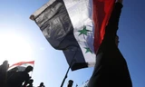 Quốc kỳ Syria được giương cao trong các cuộc biểu tình. Ảnh: Sputnik