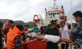 Các chiến sỹ cảnh sát biển khẩn trương đưa ngư dân lên bờ