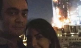 Cặp đôi chụp ảnh trước khách sạn cháy. Ảnh: News