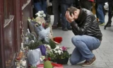 Người dân đặt hoa tưởng niệm các nạn nhân bên ngoài nhà hàng Le Carillon. Ảnh: Reuters
