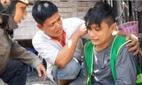 Anh Lê Anh Hựu (ở giữa) hỗ trợ một thanh niên bị tai nạn trên đường. Ảnh: NVCC