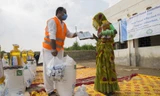 Một nhân viên WFP phát dầu ăn và bột mì cho người dân Pakistan trong tháng 9 vừa qua. Ảnh: WFP 