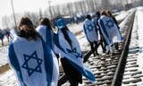 Người Israel choàng quốc kỳ lên người trong khi diễu hành trên đường ray ở trại diệt chủng Auschwitz khét tiếng của Phát xít Đức