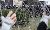 Người biểu tình cố kéo đổ hàng rào dây thép gai khi biểu tình trước Trung đoàn bộ binh số 11. (Ảnh: Reuters)