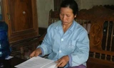 Bà Nguyễn Thị Mai (vợ ông Long) cùng những lá đơn kêu oan cho chồng.