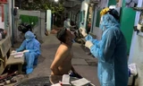 Nhân viên y tế lấy mẫu xét nghiệm những người trong khu dân cư bị cách ly.