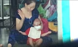 Bé trai bị kẹp đầu, liên tục bị đánh khi ăn. Ảnh cắt từ clip.